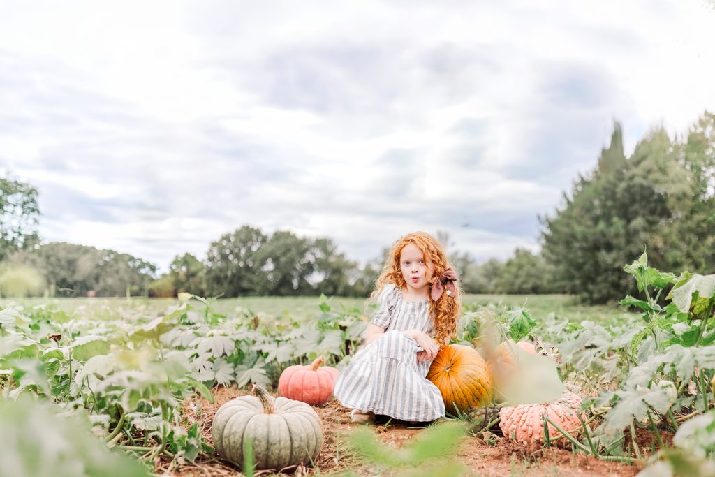 Family enjoying a fall day among pumpkins at Old Baker Farm near Birmingham, Alabama