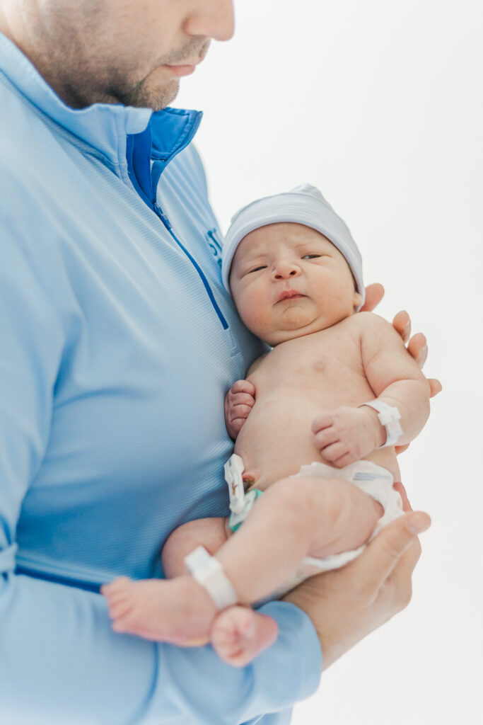 Dad holding newborn baby boy during fresh-48 session with 5U Photography