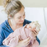 Mom sitting in hospital bed at UAB holding newborn baby girl swaddled in pink blanket during milestone membership included fresh-48 in birmingham alabama