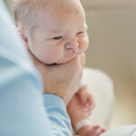 Dad holding newborn baby boy burping him after feeding during fresh-48 as the 1st milestone membership session with 5U Photography at Grandview Medical Center