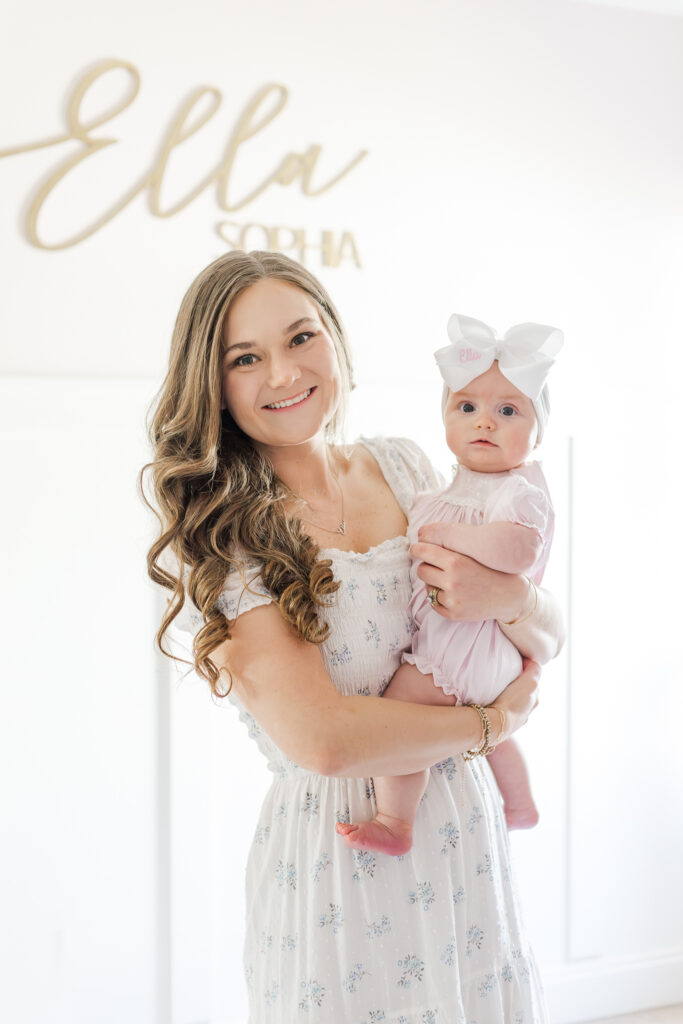 Mom holding little girl on her 1/2 birthday smiling at the camera during a session with 5U Photography