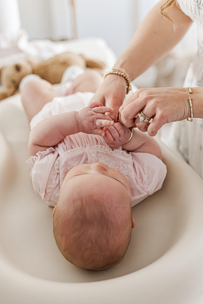Close-up of baby Ella's tiny hands holding on to her mom's finger capturing the precious details during her 6-month milestone photoshoot.