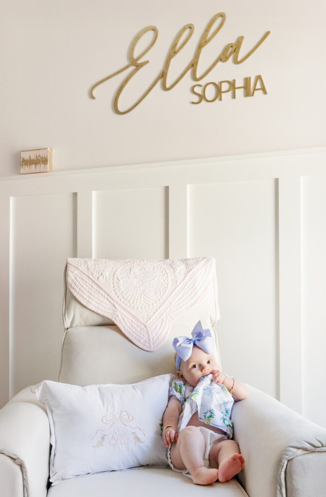 Baby Ella sitting up on her own, showing off her milestone at 6 months old in her light-filled nursery
