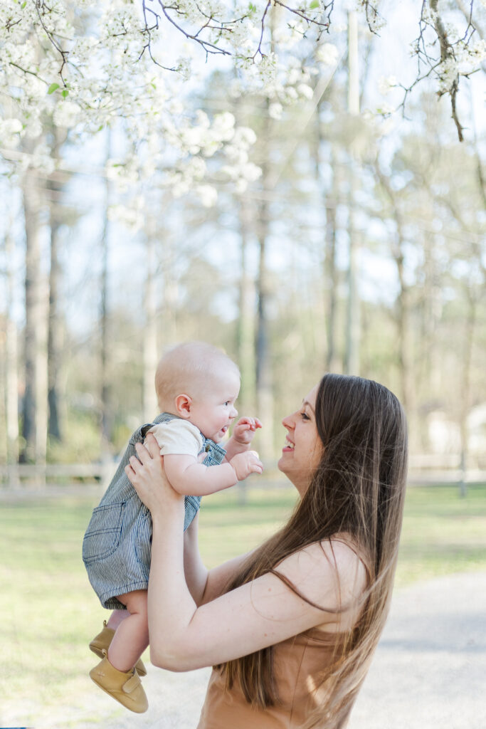 Mom gently holding baby as they share a loving look, with soft sunlight streaming in