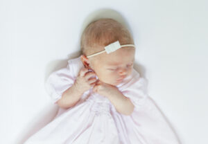 close up of eleanor sleeping peacefully with delicate white bow 