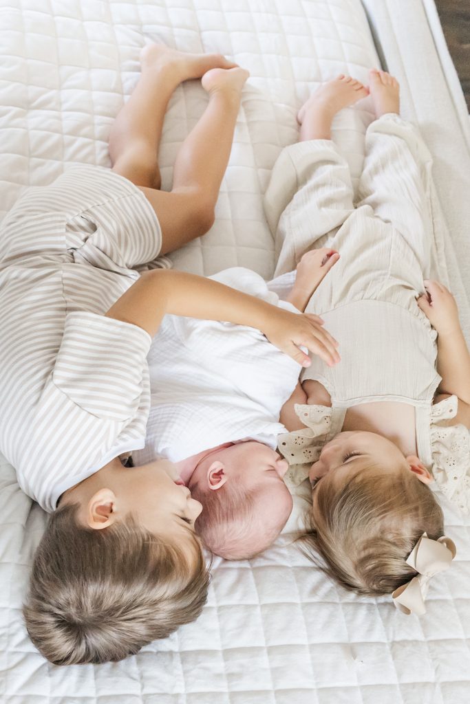 Older siblings snuggling their newborn baby during the Lavender family's in-home newborn session