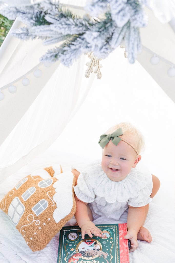 Little girl wearing a festive Christmas outfit during a Santa mini photography session.