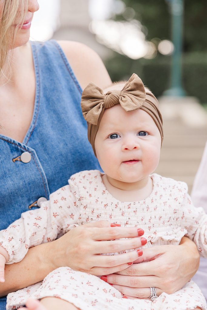Courtney holding baby Harper outdoors during their milestone session.
