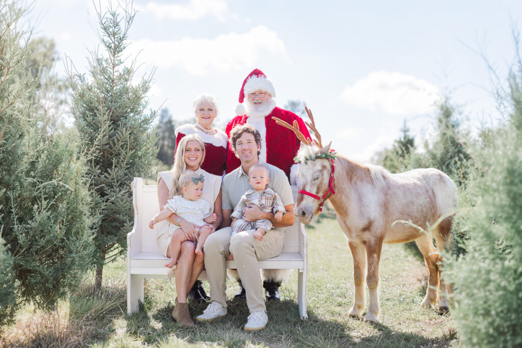 Family portrait at a Christmas tree farm in Birmingham, Alabama, surrounded by evergreen trees.
