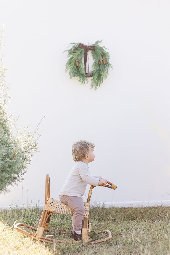 Toddler in a soft neutral Christmas outfit photographed at a tree farm.