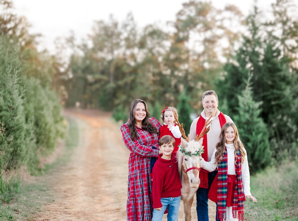 Family in festive red tartan, burgundy and cream posing with Burt the Reindeer at a Birmingham, Alabama Christmas mini session