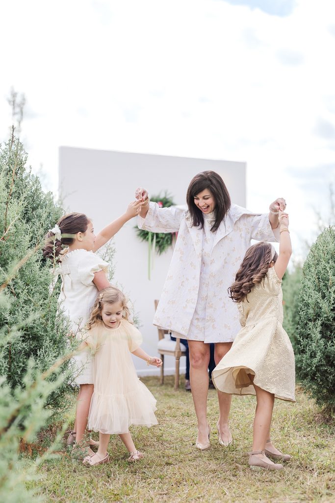 Mother with children dressed in coordinated light neutral outfits during a Christmas mini session.