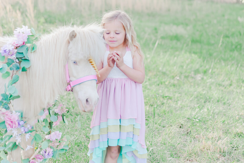 blonde haired little girl standing next to unicorn in Birmingham AL unicorn mini session