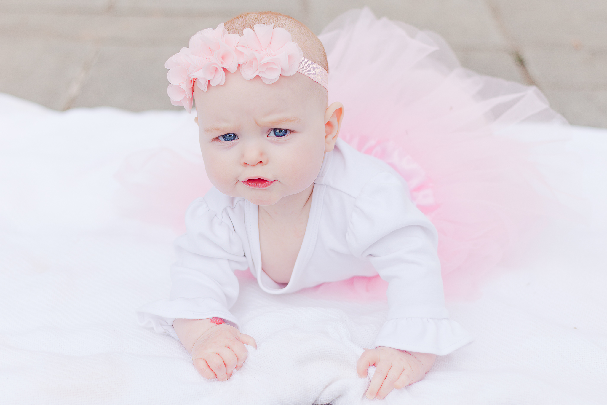 little girl lying on blanket in pink tutu looking at camera during photo session with 5U Photography