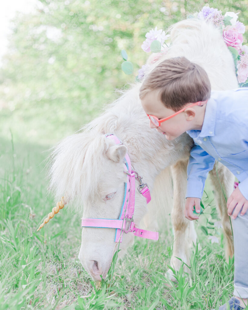 little boy leaning down whispering to unicorn during 5U Photography session