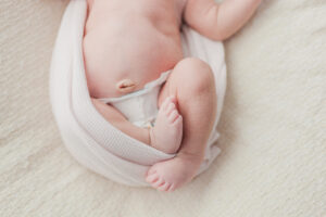 Close up of baby girl's feet wrapped in a pink blanket taken during in-home newborn session