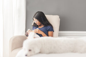 Mom sitting in rocker holding baby girl feeding her a bottle