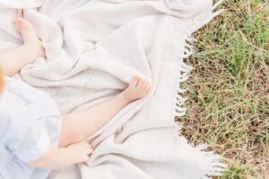 Little boys feet on blanket in the grass during photo session with 5U Photography