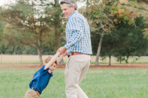 dad spinning 6 year old son around, son smiling 