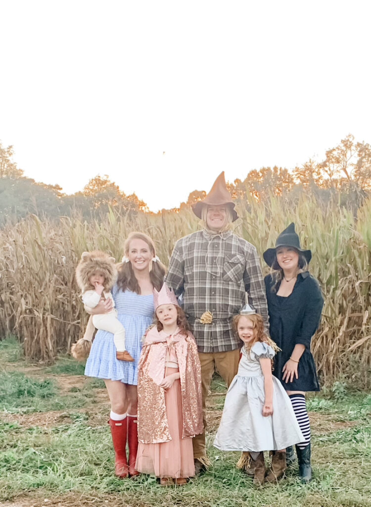 Owner of 5U Photography standing with family in front of cornfield at Old Baker Farm pumpkin patch in Birmingham Alabama