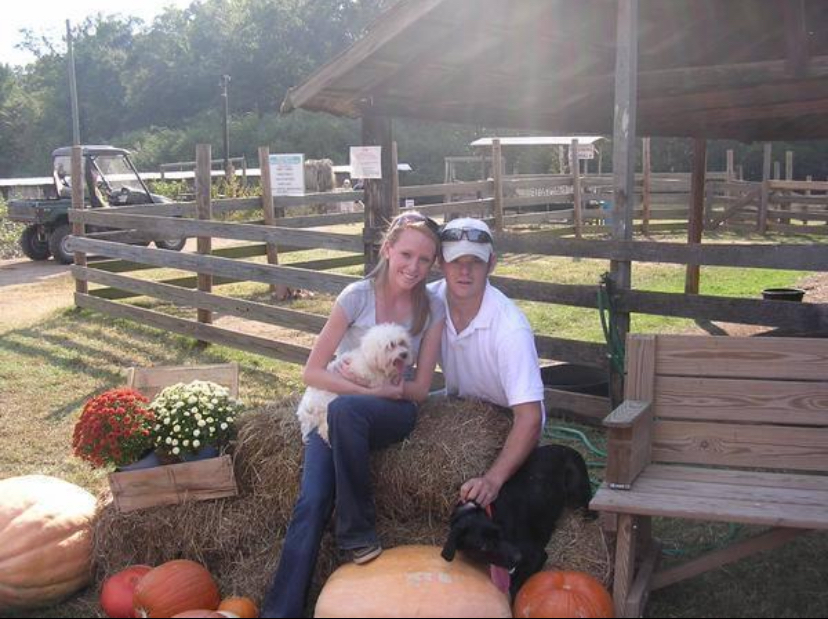 couple sitting on hay bales at pumpkin patch in Birmingham Alabama