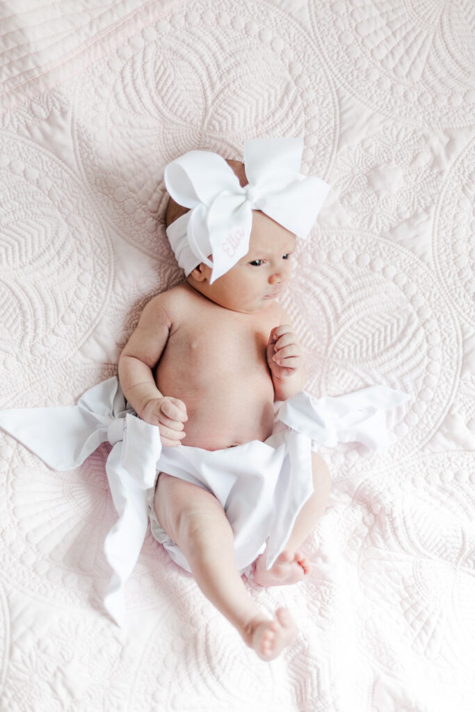 Newborn baby girl Ella surrounded by delicate pink blanket, capturing the essence of her beauty during the lifestyle newborn session in Birmingham, Alabama