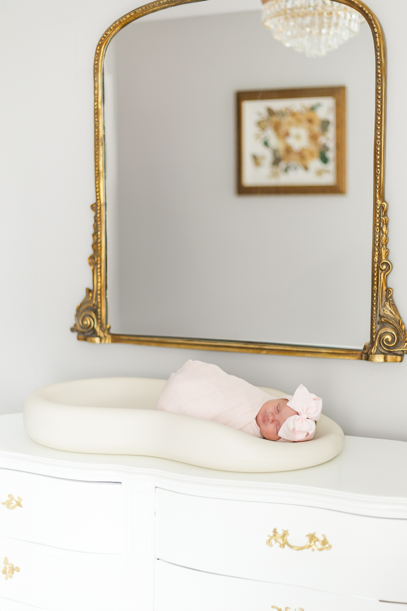 Close-up of baby girl Ella wrapped in a soft, pastel-colored blanket, highlighting her delicate features and peaceful expression during the lifestyle session