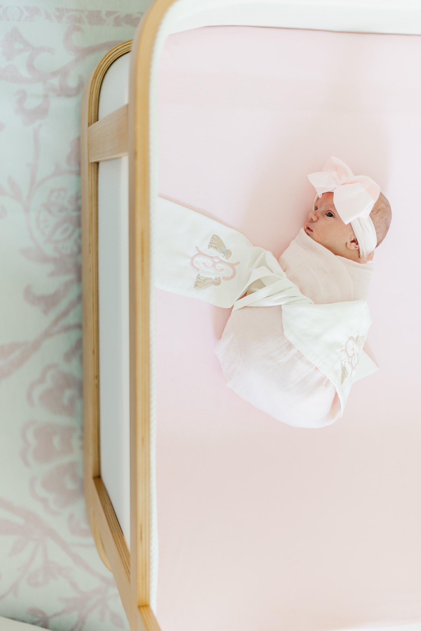 A peaceful newborn sleeping in a cozy crib, surrounded by soft blankets during 5U Photography newborn session