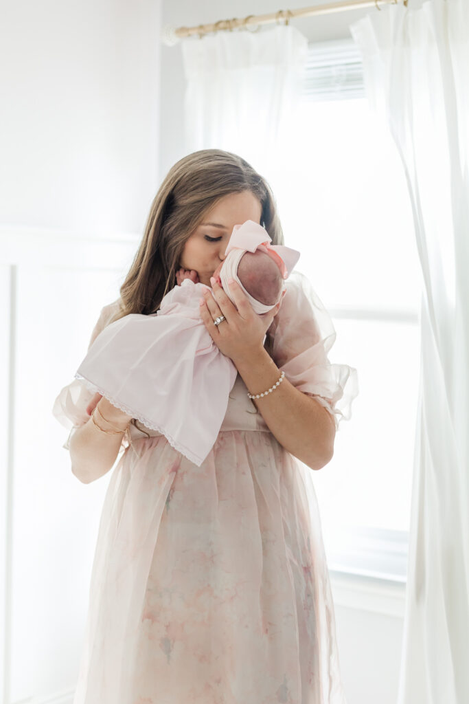 A tender moment between a mother and her newborn daughter, with soft natural light illuminating their faces in the living room