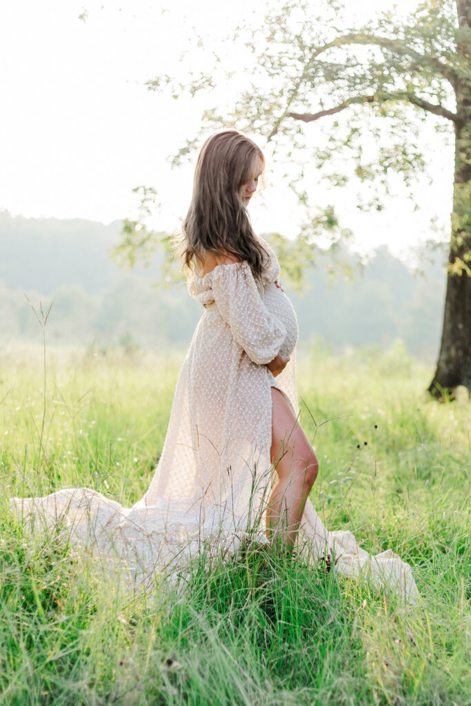 mother looking down at baby bump during maternity session at morgan creek vineyard