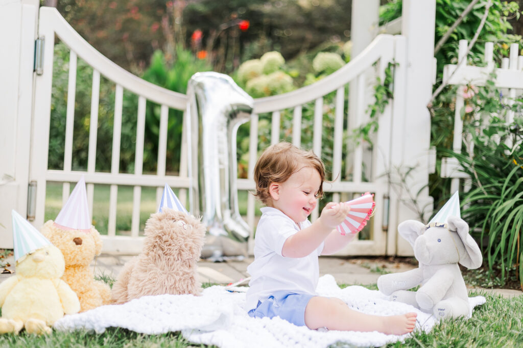 A candid shot of Max laughing while playing in the gardens, capturing the joy of his 1st birthday session