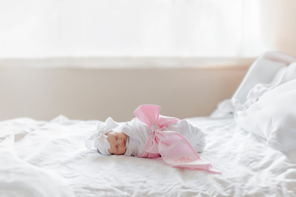 Fresh 48 session capturing a newborn baby in the hospital room at Grandview Medical Center in Birmingham, Alabama. The image showcases the baby swaddled in a soft blanket lying on mother's hospital bed with eyes closed 