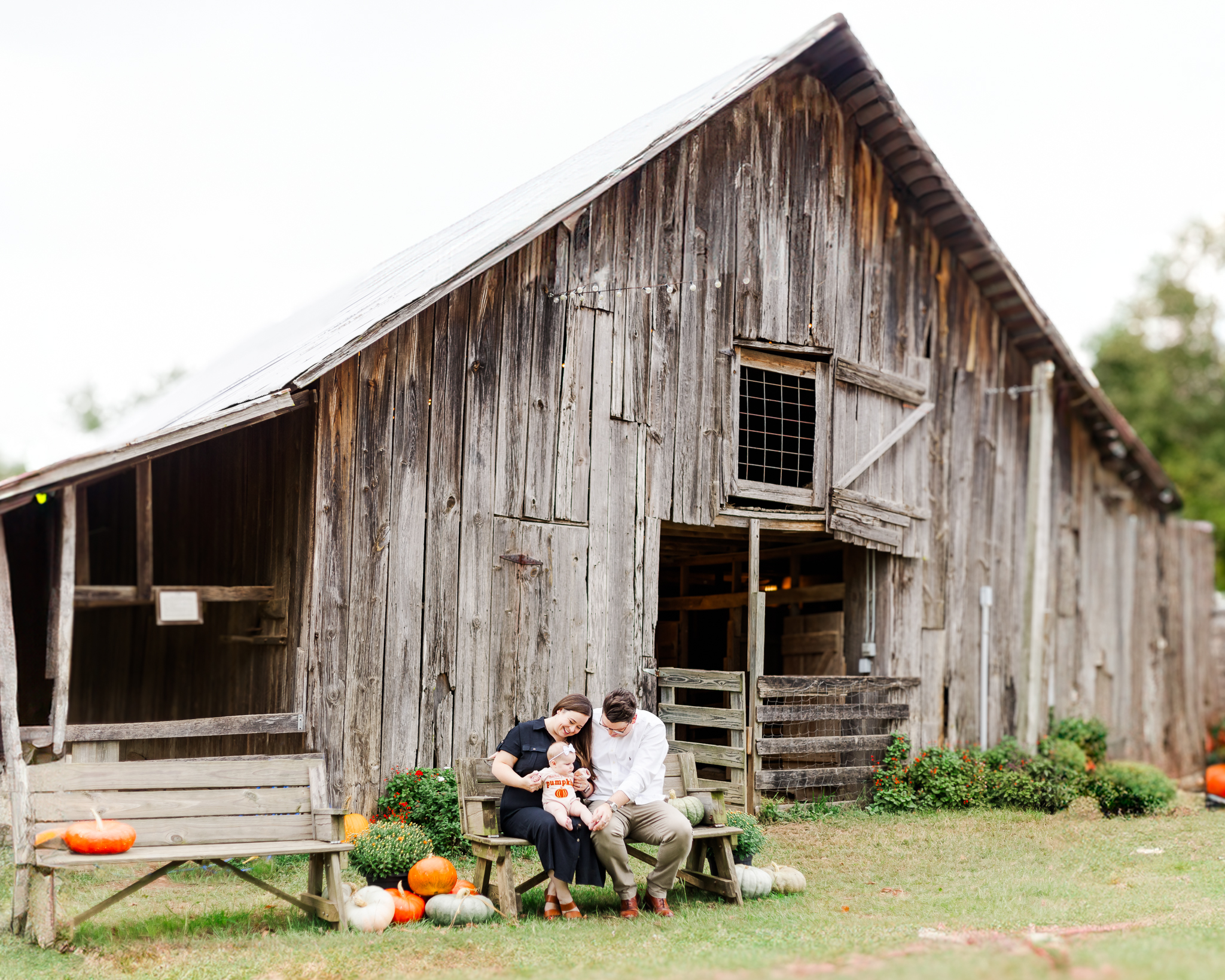 Family sitting in front of weathered barn at Old Baker Farm during 6 Month Milestone session with 5U Photography in birmingham alabama