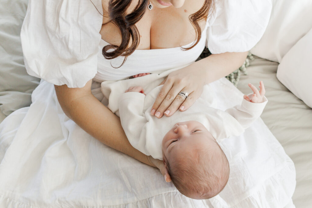 Close-up of newborn baby boy’s delicate face, with soft features and a peaceful expression, captured in natural light.