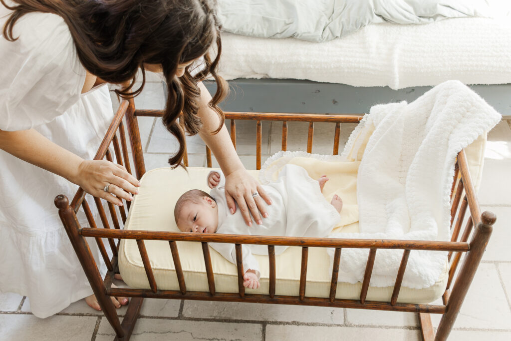 Newborn baby boy peacefully sleeping in a basket, surrounded by soft, textured blankets in a cozy home setting