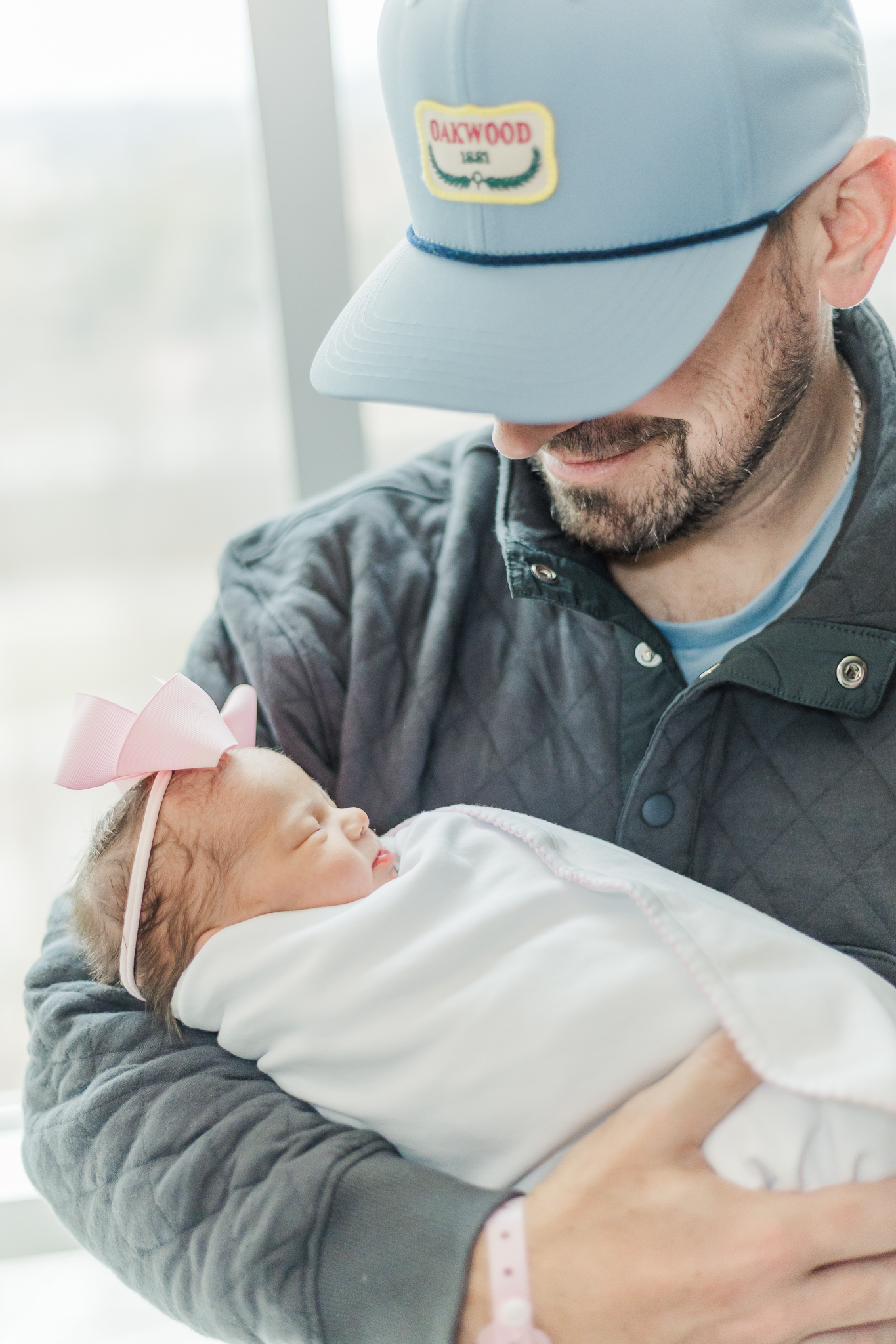 A tender moment as a dad gazes lovingly at their newborn daughter, Ella Jo, in the hospital during the Fresh 48 session