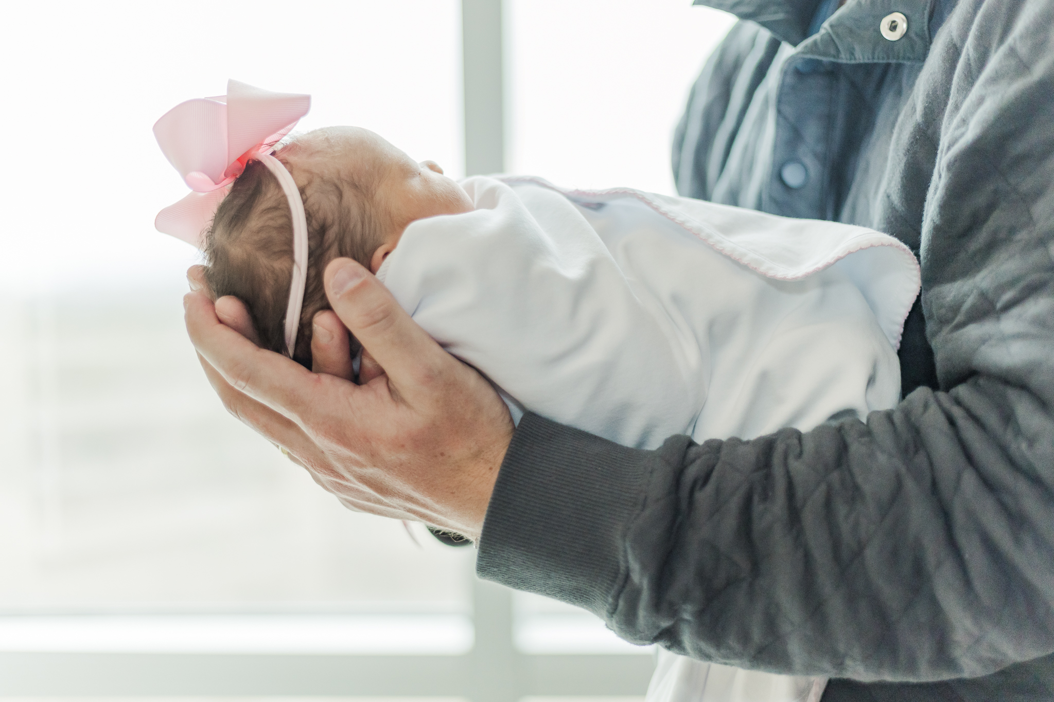 Close up of dad's hands holding newborn baby girl during fresh-48 session with 5U Photography