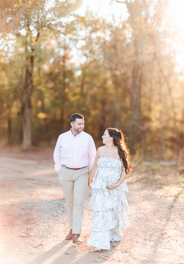 Pregnant woman with partner, captured by 5U Photography in a serene outdoor setting, wearing a boho maternity dress surrounded by nature