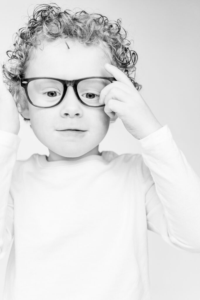 little boy with glasses on looking at camera during personality portrait party session with 5U Photography in birmingham alabama 