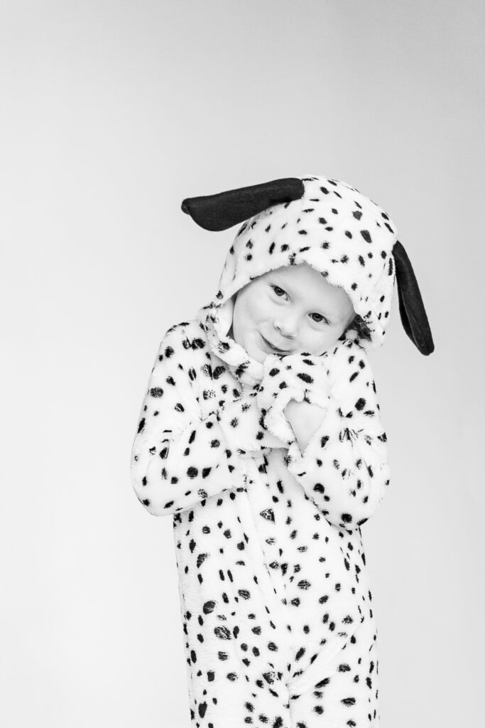 Little boy smiling at camera in dalmation costume during personality portrait party 