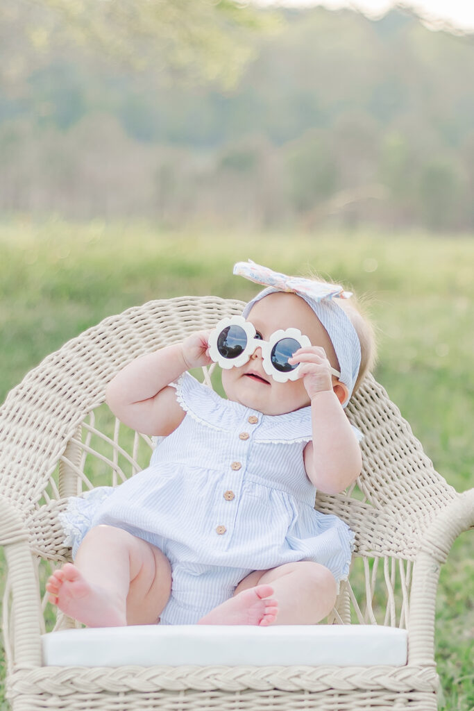 Baby giggling and looking up at the camera, surrounded by natural greenery and soft boho decor in a beautiful 6-month milestone session in Birmingham, Alabama