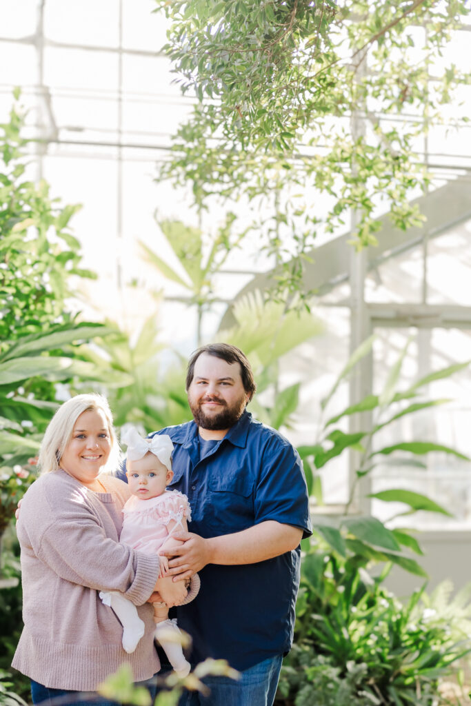 Miss Maggie and her family posing together in the beautiful Birmingham Botanical Gardens for her 12-month milestone photoshoot, captured by 5U Photography