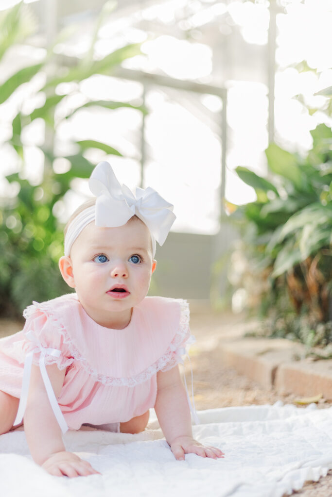 Beautiful portrait in the vibrant flowers of Birmingham Botanical Gardens greenhouses, capturing Miss Maggie’s first birthday milestone