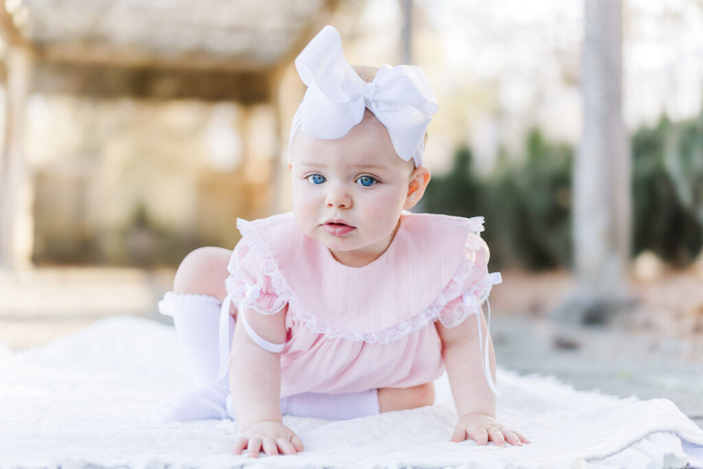 1st birthday girl crawling on blanket at the birmingham botanical gardens