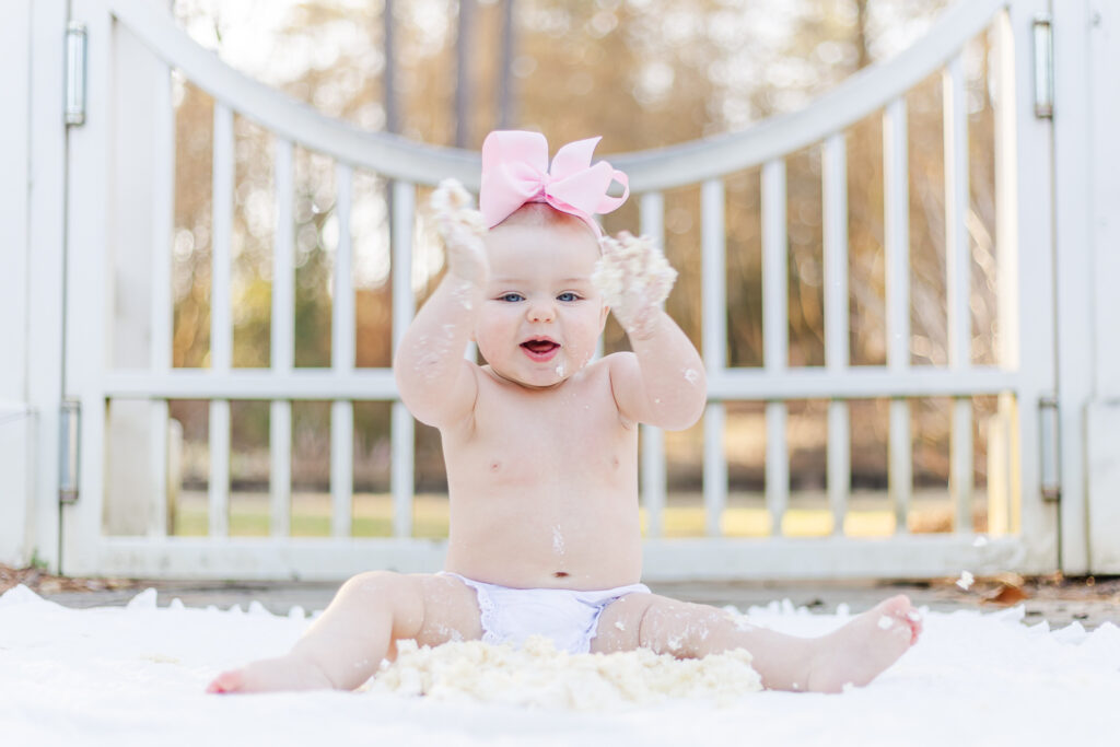 Family gathered around Miss Maggie, celebrating her 12-month birthday with laughter and joy at Birmingham Botanical Gardens, photographed by 5U Photography