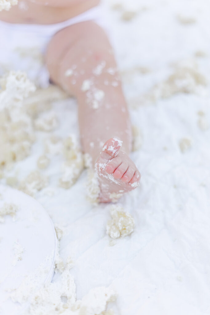 Close up of baby girls feet covered in frosting after cake smash session