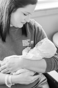 black and white picture of mom looking down at newborn baby lovingly in hospital room at St. Vincent's hospital 
