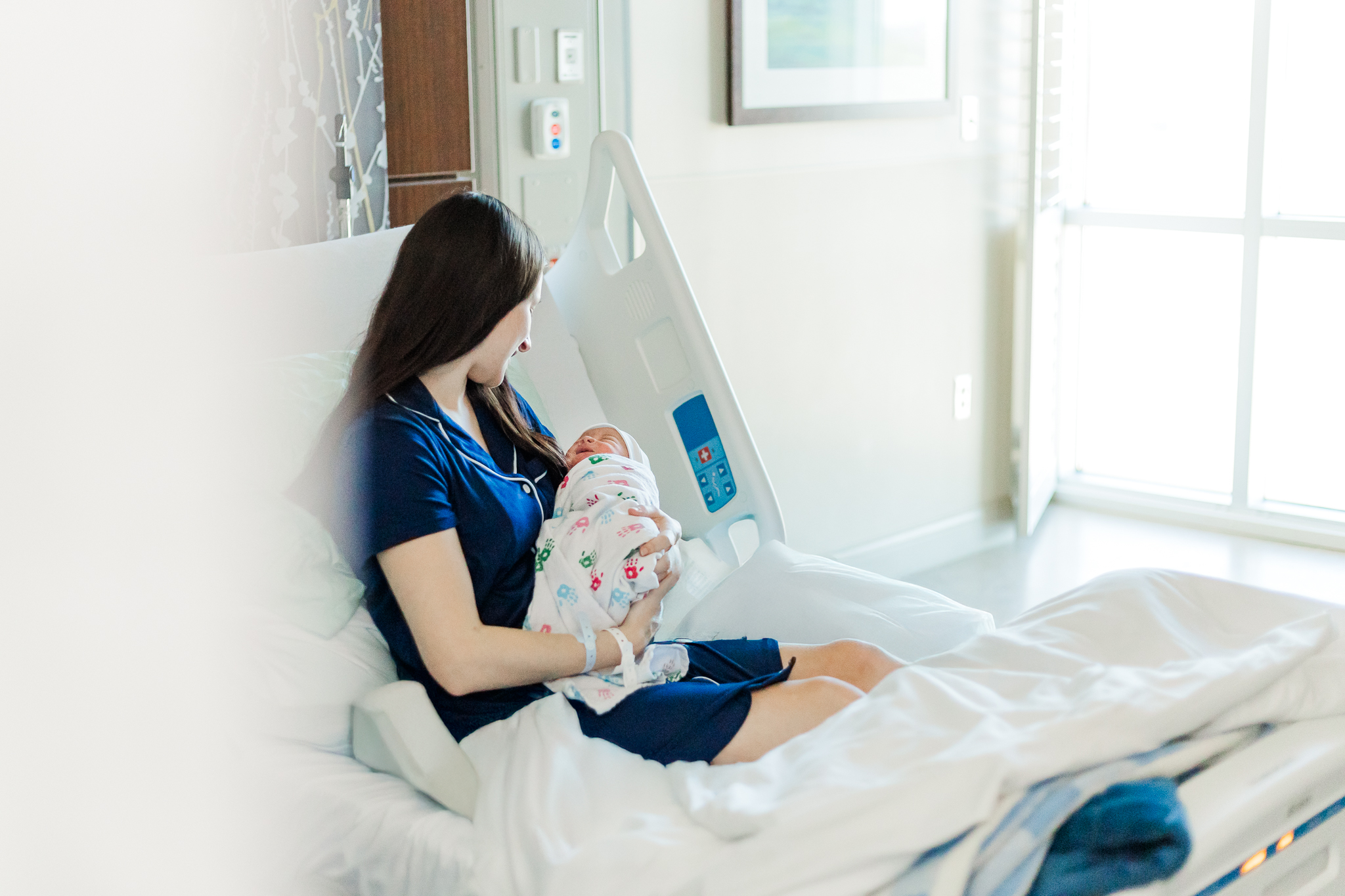 Mom holding newborn baby boy sitting in hospital bed at Brookwood Hospital in Birmingham AL during fresh-48 session with 5U Photography