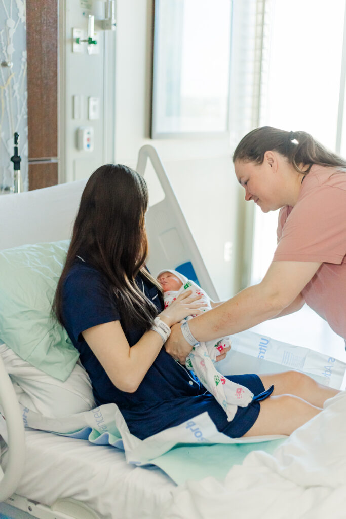 Mom Kinsley gently holding baby Ezra in her arms, capturing the tender bond between mother and son.