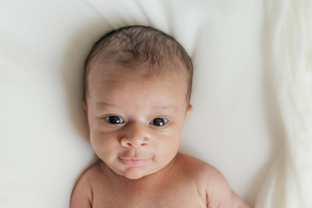 close up of newborn baby boy looking at the camera during photo session with 5U Photography